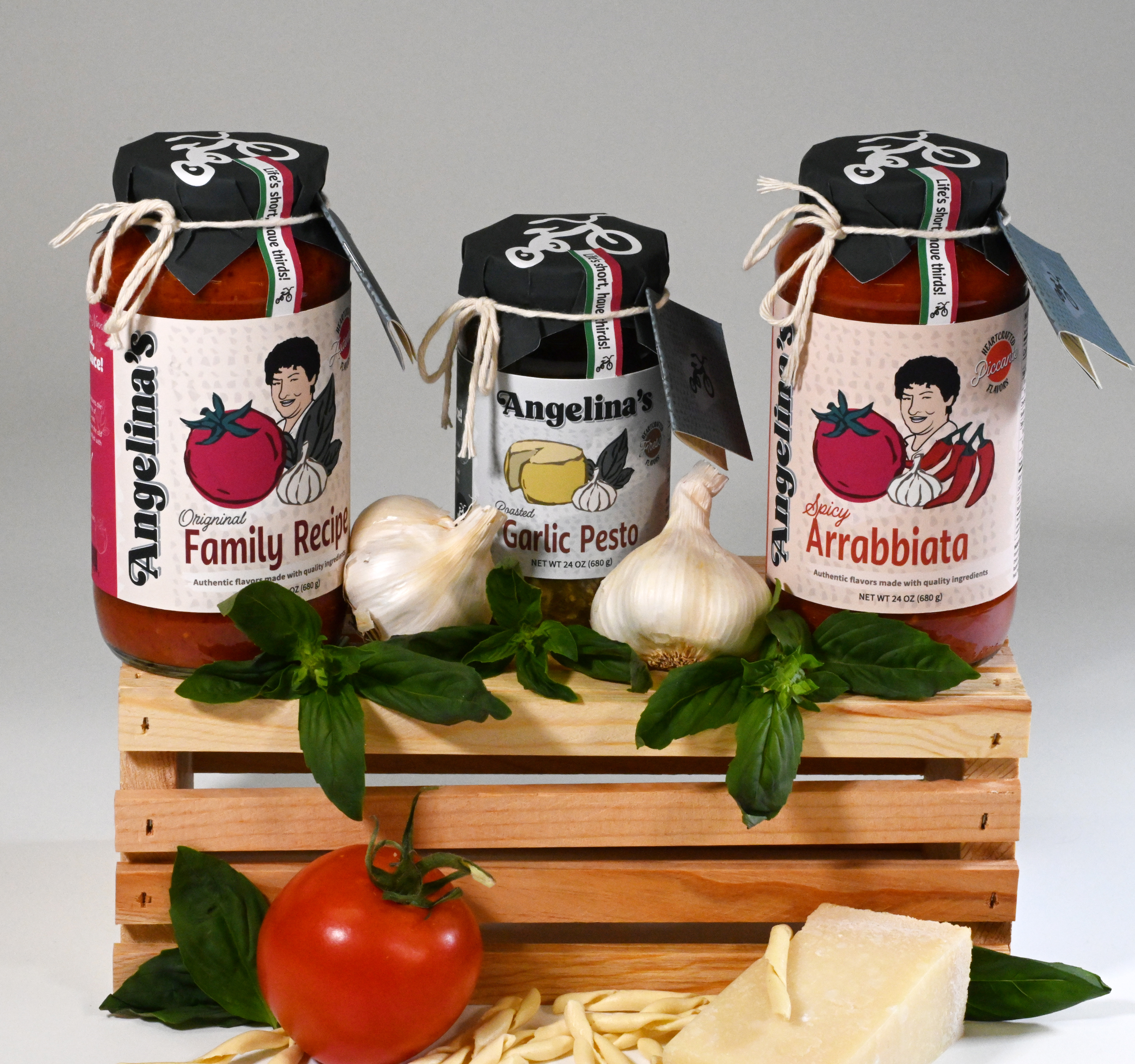 Angelinas jars sitting on a wooden crate with basil garnishes